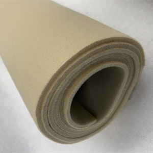 May include: A roll of beige upholstery foam, a type of padding used for furniture and other applications.