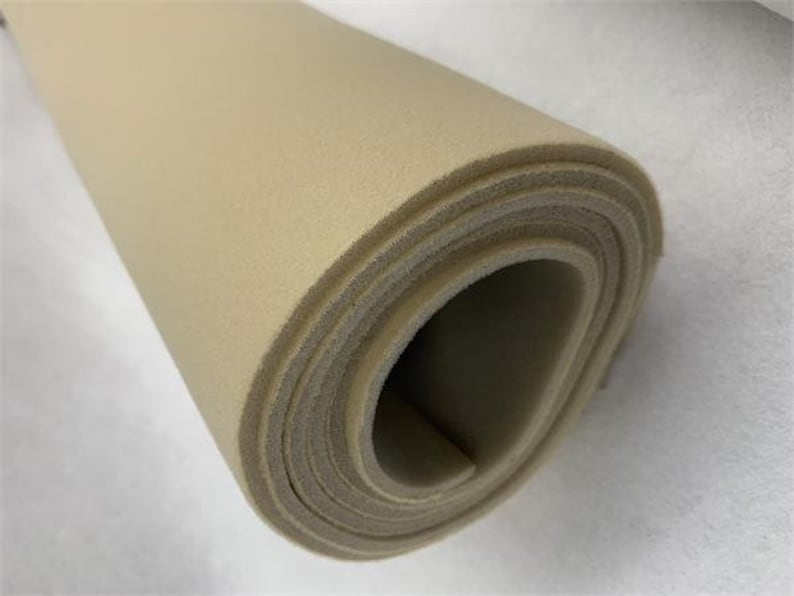 May include: A roll of beige upholstery foam, a type of padding used for furniture and other applications.