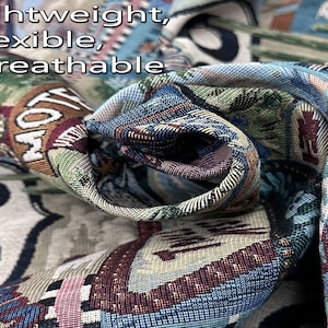 May include: Close-up of a woven fabric with a blue, green, and red pattern. The fabric is folded and shows the texture of the weave. The text "Lightweight, Flexible, Breathable" is visible at the top of the image.