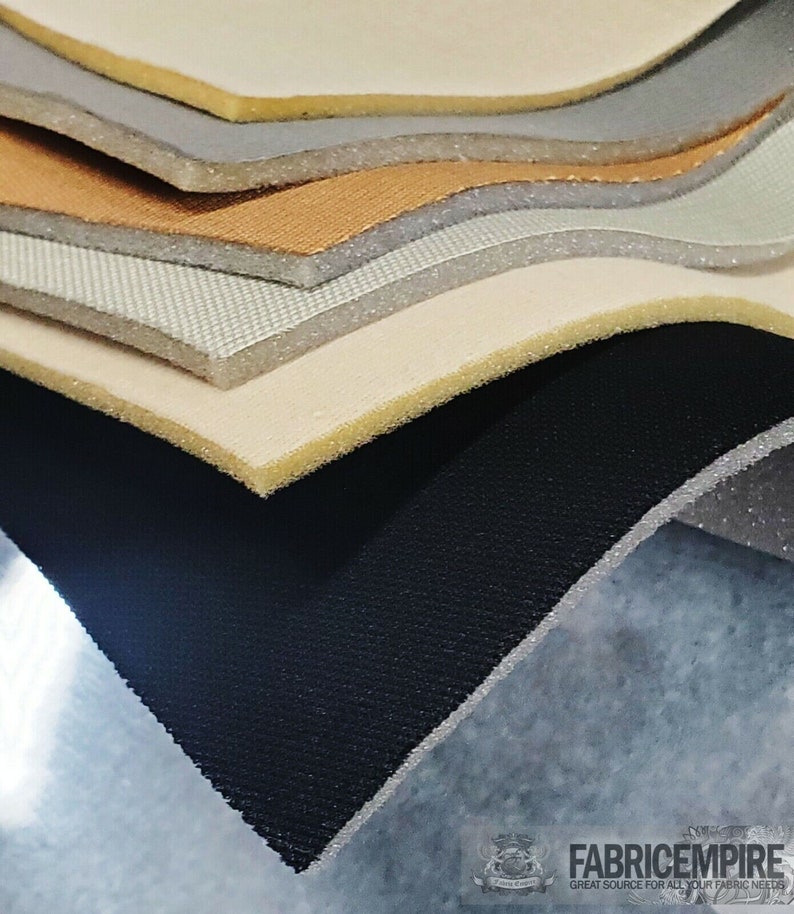 May include: A close-up of a stack of different types of fabric, including black, white, beige, brown, and gray. The fabric is arranged in a staggered pattern, with the top layer of fabric being black.