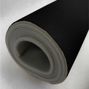 May include: A roll of black fabric with a gray foam backing. The fabric is rolled up tightly, showing the foam backing.