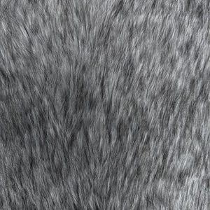 May include: A close-up view of a gray faux fur textile. The fur has long, soft strands with a mix of light and dark gray hues, creating a textured, fluffy appearance. The fibers are densely packed, giving the fabric a luxurious look.