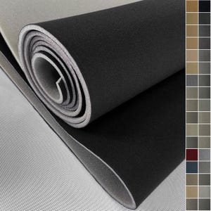 Puede incluir: Un material de espuma negro enrollado con un borde gris, parcialmente desenrollado para revelar una superficie gris texturizada. El material parece grueso y duradero, adecuado para diversas aplicaciones.