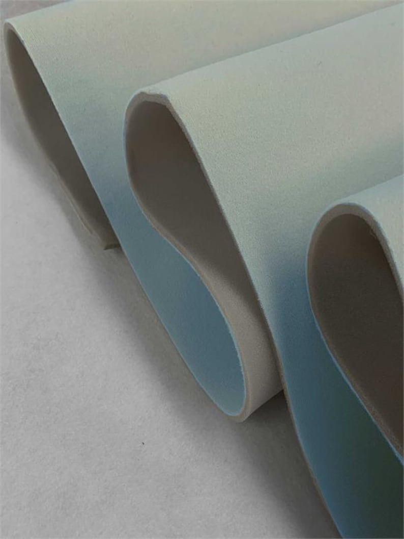 May include: Close-up of a folded piece of light blue and white fabric. The fabric has a soft, velvety texture.