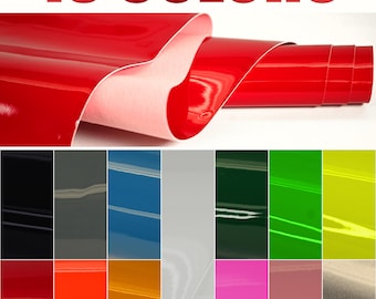 May include: A roll of glossy red vinyl material is partially unrolled, revealing a white backing. Below, a grid displays samples of 13 different vinyl colors, including black, gray, blue, white, green, yellow, red, orange, and pink. The text "13 COLORS" is at the top.
