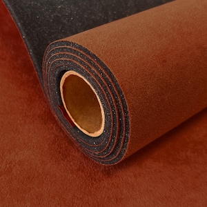 May include: A rolled sheet of material featuring a soft, rust-colored felt top layer and a textured, black foam backing. The roll is coiled tightly, revealing the layered structure of the brown fabric and the dark, granular underside of the material.