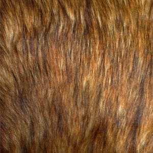 May include: Close-up of a brown faux fur fabric with a mix of light and dark brown strands. The texture is dense and the strands are long, creating a soft, fluffy appearance. The overall colour palette is warm and natural.