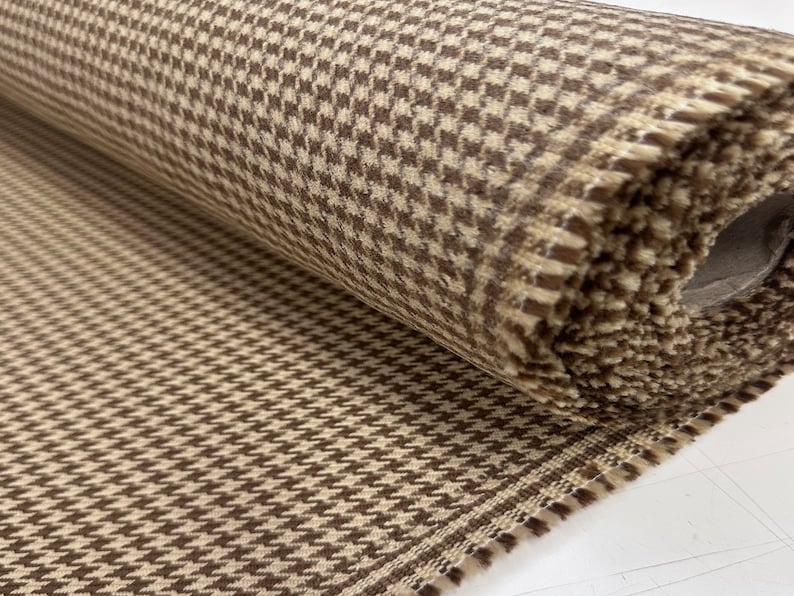 May include: A roll of brown and beige fabric with a houndstooth pattern.