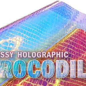Op de afbeelding: Glanzend holografisch krokodiltextuur materiaal in tinten blauw, paars en goud. De afbeelding bevat de tekst "GLOSSY HOLOGRAPHIC CROCODILE", wat duidt op een product voor knutselen of design.