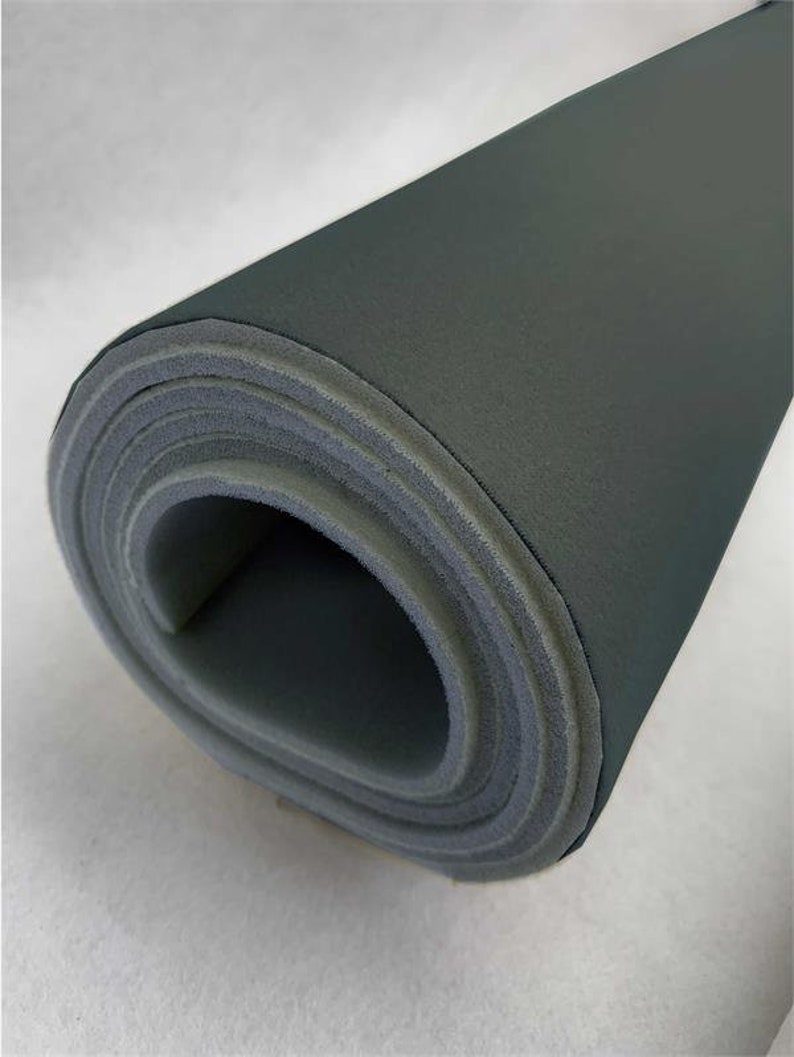 May include: A roll of dark gray foam insulation material. The foam is rolled up tightly and the edges are visible.