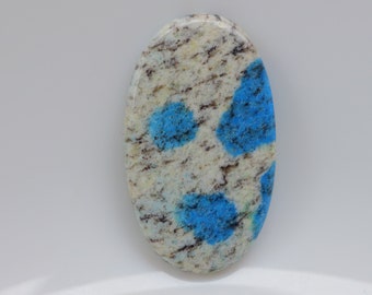 May include: Oval shaped blue and white gemstone cabochon with a speckled pattern.
