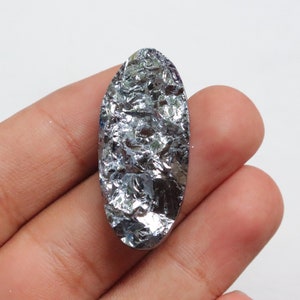 May include: A silver-colored, oval-shaped, raw, natural silicon crystal. The crystal has a rough, textured surface.
