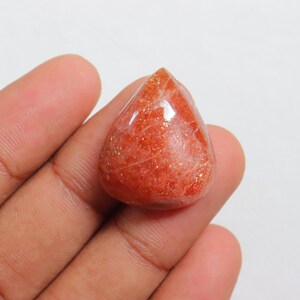 Pu&ograve; includere: Un cabochon di pietra di sole a forma di lacrima, di colore rosso-arancione e con una finitura scintillante e iridescente.