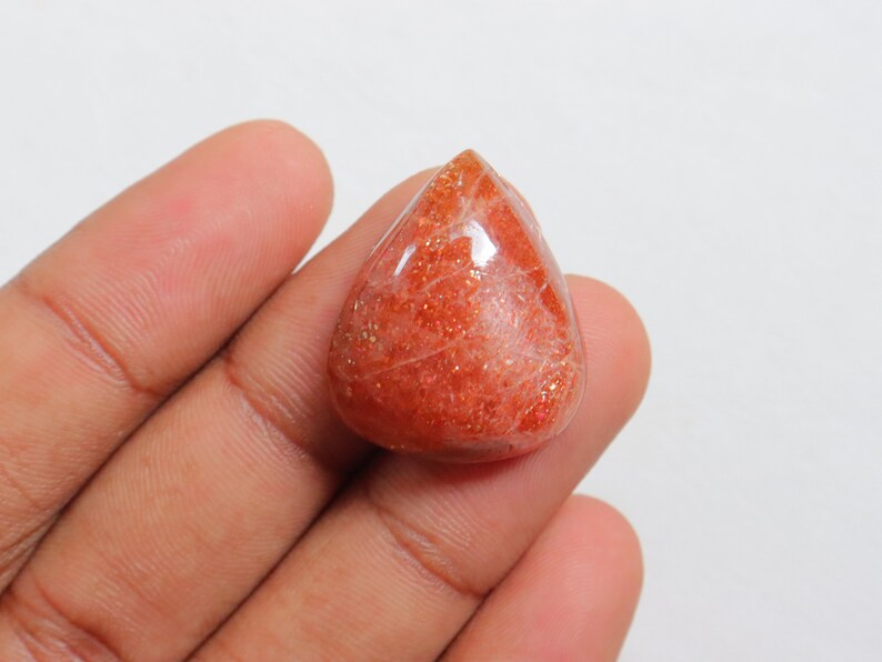 Pu&ograve; includere: Un cabochon di pietra di sole a forma di lacrima, di colore rosso-arancione e con una finitura scintillante e iridescente.