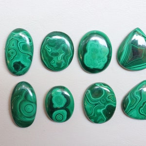 Puede incluir: Ocho cabujones de malaquita verde de diferentes formas y tama&ntilde;os. Los cabujones tienen un patr&oacute;n de remolino de verde y negro.