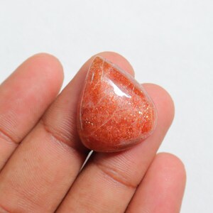Pu&ograve; includere: Un cabochon di pietra di sole a forma di lacrima, di colore arancione e rosso traslucido. La pietra ha una qualit&agrave; scintillante e iridescente.