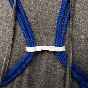 A white string backpack sternum clip