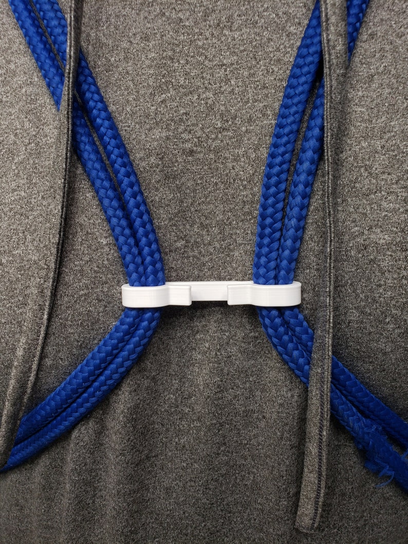 A white string backpack sternum clip
