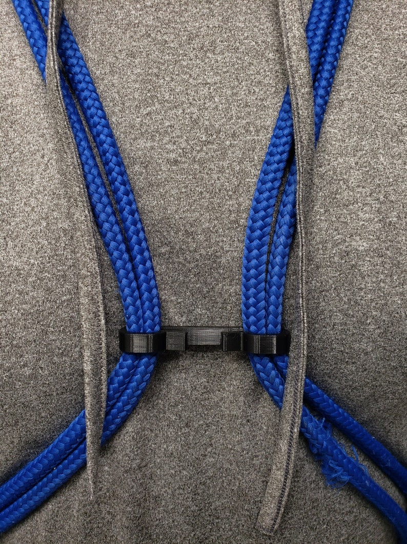 A black drawstring bag clip meant for doubled corded bag