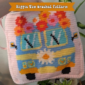 May include: A crocheted hippie van with flowers on top. The van is blue, yellow, and orange. The flowers are pink, orange, and white.
