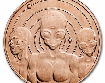May include: A copper-colored round coin or medallion featuring three alien figures with large eyes and smooth heads. The aliens are centered, with a planetary orbit design in the background. The coin has a metallic sheen.