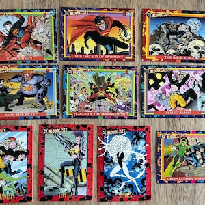 May include: A collection of DC Comics "Bloodlines" trading cards. Each card features colorful illustrations of superheroes and villains in action, with text labels such as "Superboy" and "The Rage King". The cards have a red border.