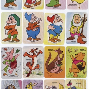 May include: A set of 16 colorful playing cards featuring characters from Disney's Winnie the Pooh and Snow White. The cards are rectangular and have a white background with a colorful illustration of a character on each card. The characters include Winnie the Pooh, Piglet, Tigger, Eeyore, Rabbit, Kanga, Roo, Owl, Snow White, Bashful, Doc, Dopey, Grumpy, Happy, Sleepy, and Sneezy.