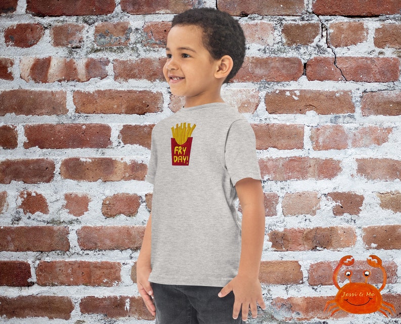 May include: A grey t-shirt with a graphic of french fries in a red box and the text "Fry Day!" printed on the front.
