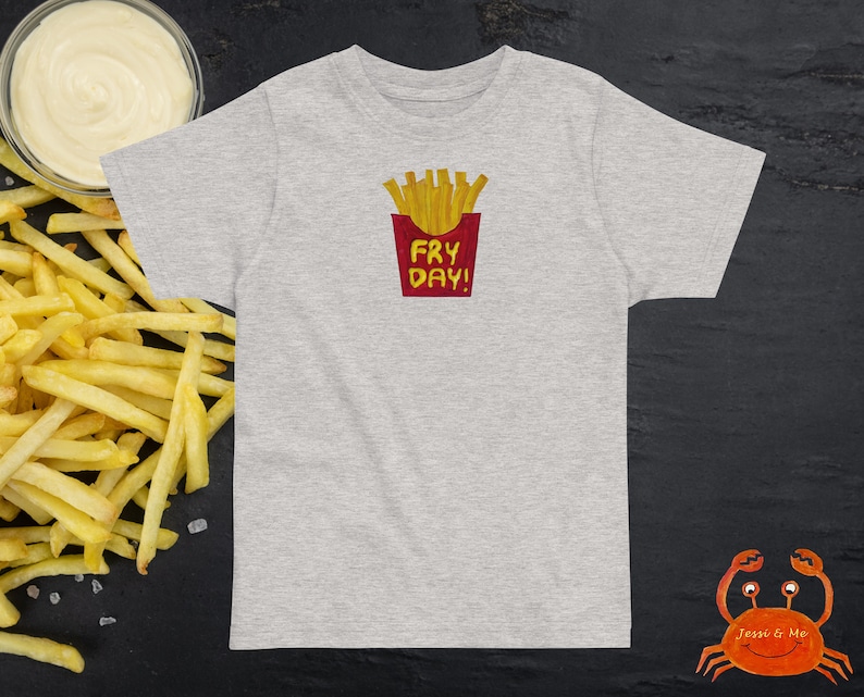 May include: Grey t-shirt with a red box and the text "Fry Day!" inside. The box contains a cartoon image of chips.