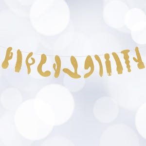 May include: A gold glitter garland with various shapes of adult toys hanging from a string.