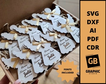 May include: A box filled with wooden angel ornaments with a gold ribbon and the text "Pierwsza Komunia Swieta Julii 14.06.2028" on each. The box is surrounded by a white background with the text "FONTS INCLUDED" in a peach circle.
