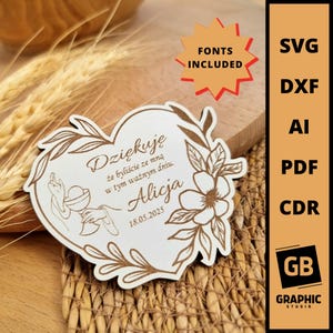 Op de afbeelding: Een houten hartvormig aandenken met bloemen- en bladeraccenten. De tekst "Dziękuję" en "Alicja 18.05.2025" zijn op het oppervlak gegraveerd. Een ster met "FONTS INCLUDED". De rechterkant toont bestandsformaten.