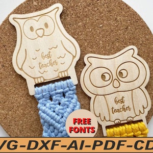 May include: Two wooden owl shapes with the text "best teacher" on them. The owls are attached to a blue and yellow string.