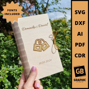 Op de afbeelding: Een houten gastenboek met een gouden gegraveerd ontwerp van twee sloten met harten. Het boek is getiteld "Dominika i Dawid" en de datum "19.05.2024" staat onder het ontwerp.