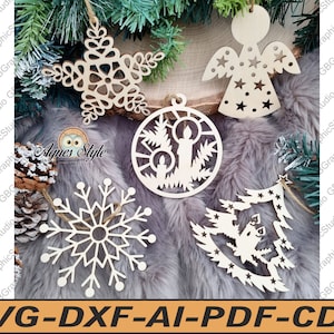 Puede incluir: Cinco adornos navideños de madera con intrincados diseños recortados. Los adornos incluyen una estrella, un copo de nieve, un árbol, un ángel y una vela en una ventana.