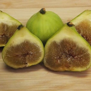 May include: Five figs, four of which are cut in half, revealing their brown flesh and seeds. One fig is whole and green.
