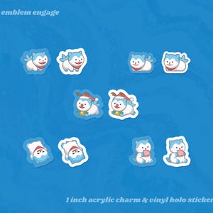 May include: A collection of acrylic charms and vinyl holo stickers. The stickers depict cartoon characters with blue fur, red scarves, and festive hats. The stickers are approximately 2.5 cm in size, set against a blue background. Text reads "fire emblem engage".