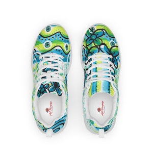 May include: White sneakers with a colorful abstract design featuring blue, green, and yellow colors. The design includes flowers and wavy lines. The sneakers have white laces and a white sole. The text "Art Purpose" is printed on the inside of the shoe.