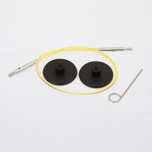 May include: A set of two black circular knitting needles with a yellow cord connecting them. The needles have a silver metal tip and a small screw on the end. The set also includes a small silver metal hook and a silver metal needle.