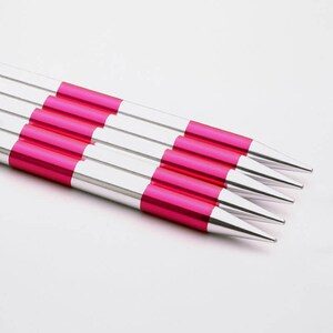 May include: Set of four silver and pink knitting needles. The needles are pointed and have a smooth finish.