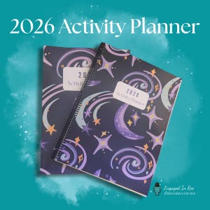May include: Two spiral-bound 2026 Activity Planners. The covers are dark blue with a celestial design of swirling lines, stars, and crescent moons in purple, orange, and white. Each planner has a white label with the text "2026 Activity Planner".