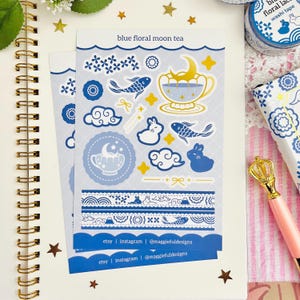May include: Two sticker sheets with a blue floral moon tea design. The stickers depict fish, clouds, rabbits, and teacups with moons. The text "blue floral moon tea" is at the top. The bottom of the sheets have the text "etsy | instagram | @maggiefuldesigns".