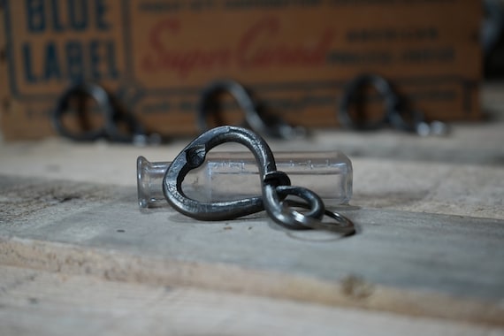 Actually hand-forged from metal at a forge — a bottle opener keychain with visible hammer marks and rustic character that you can feel was made by a human, not a machine.