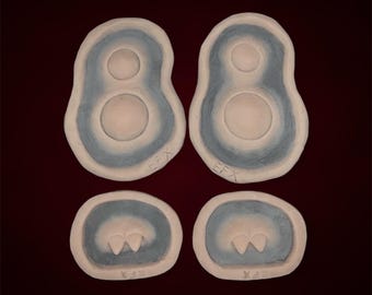 May include: Four silicone molds for making polymer clay earrings. Two molds are shaped like a figure eight with two circles inside. The other two molds are shaped like a crescent moon with two small circles inside. The molds are gray and have the text "EFX" and "X15" on them.