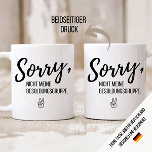 May include: Two white ceramic mugs with black text that reads "Sorry, NOT MY PAY GRADE" and a peace sign. The mugs are printed on both sides. The text "BEIDSEITIGER DRUCK" is above the mugs.