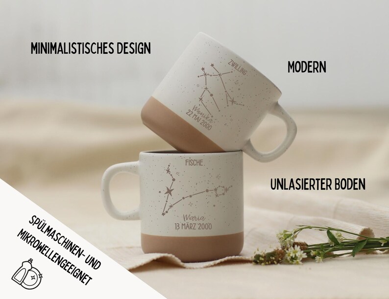 May include: Two stacked white ceramic mugs with speckled finish and tan bases. Each mug features a constellation design and text. The mugs are labeled "Zwillling" and "Fische". The text "Minimalistisches Design", "Modern", and "Sp&uuml;lmaschinen- und Mikrowellengeeignet" are also visible.