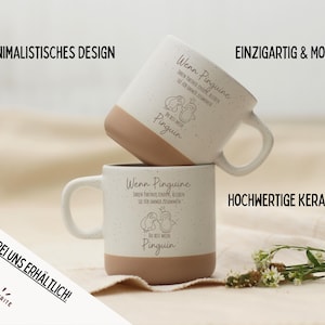 Puede incluir: Dos tazas de cer&aacute;mica blanca con un acabado moteado y bases marrones apiladas. Cada taza presenta una ilustraci&oacute;n de ping&uuml;ino y texto en alem&aacute;n. Las tazas tienen un dise&ntilde;o minimalista y est&aacute;n hechas de cer&aacute;mica de alta calidad.