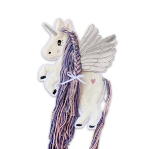 May include: A white unicorn with a pink and purple braided mane and tail. The unicorn has silver wings and a small pink heart on its side.