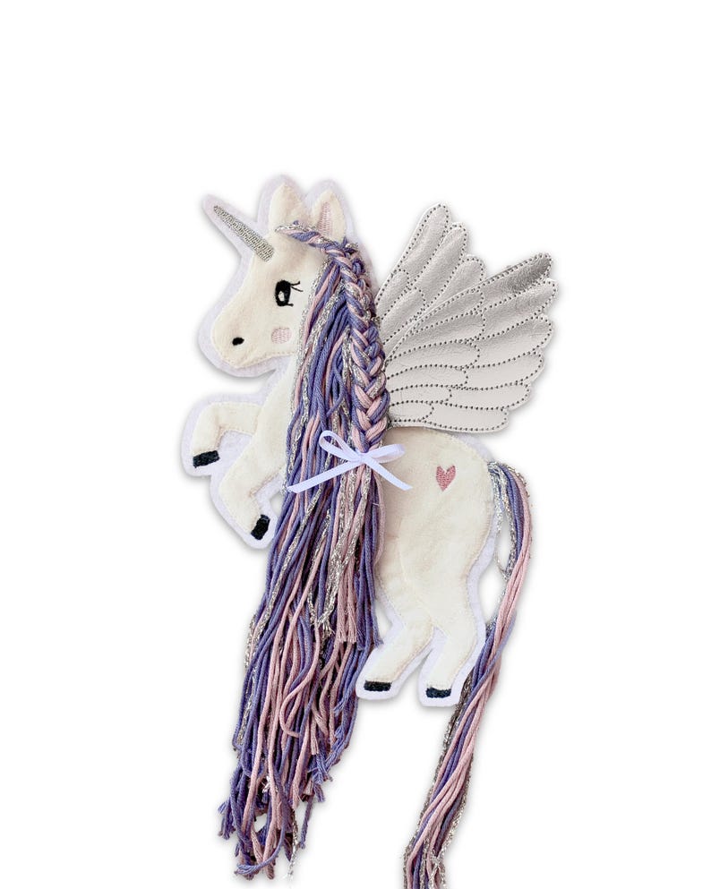 May include: A white unicorn with a pink and purple braided mane and tail. The unicorn has silver wings and a small pink heart on its side.