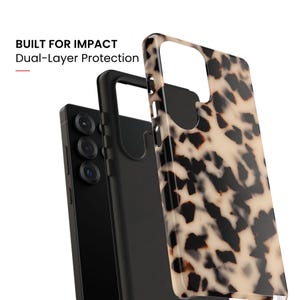 May include: A smartphone case with a beige and black tortoiseshell pattern, shown alongside a solid black inner layer and a black smartphone. The text BUILT FOR IMPACT Dual-Layer Protection is visible in the upper left corner of the image.